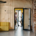 grupka pracowników stojąca obok oznaczenia w biurze